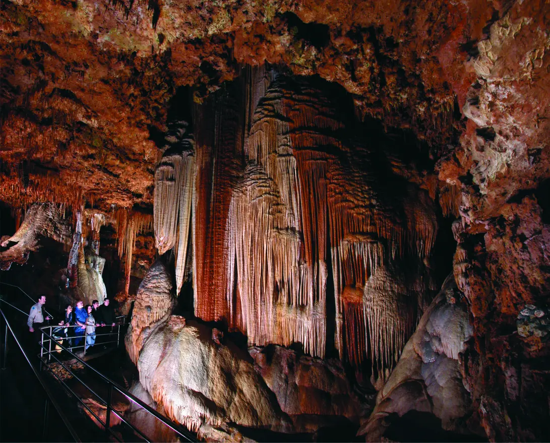 Color photo of a group of guests admiring the stalactites at Meramec Caverns