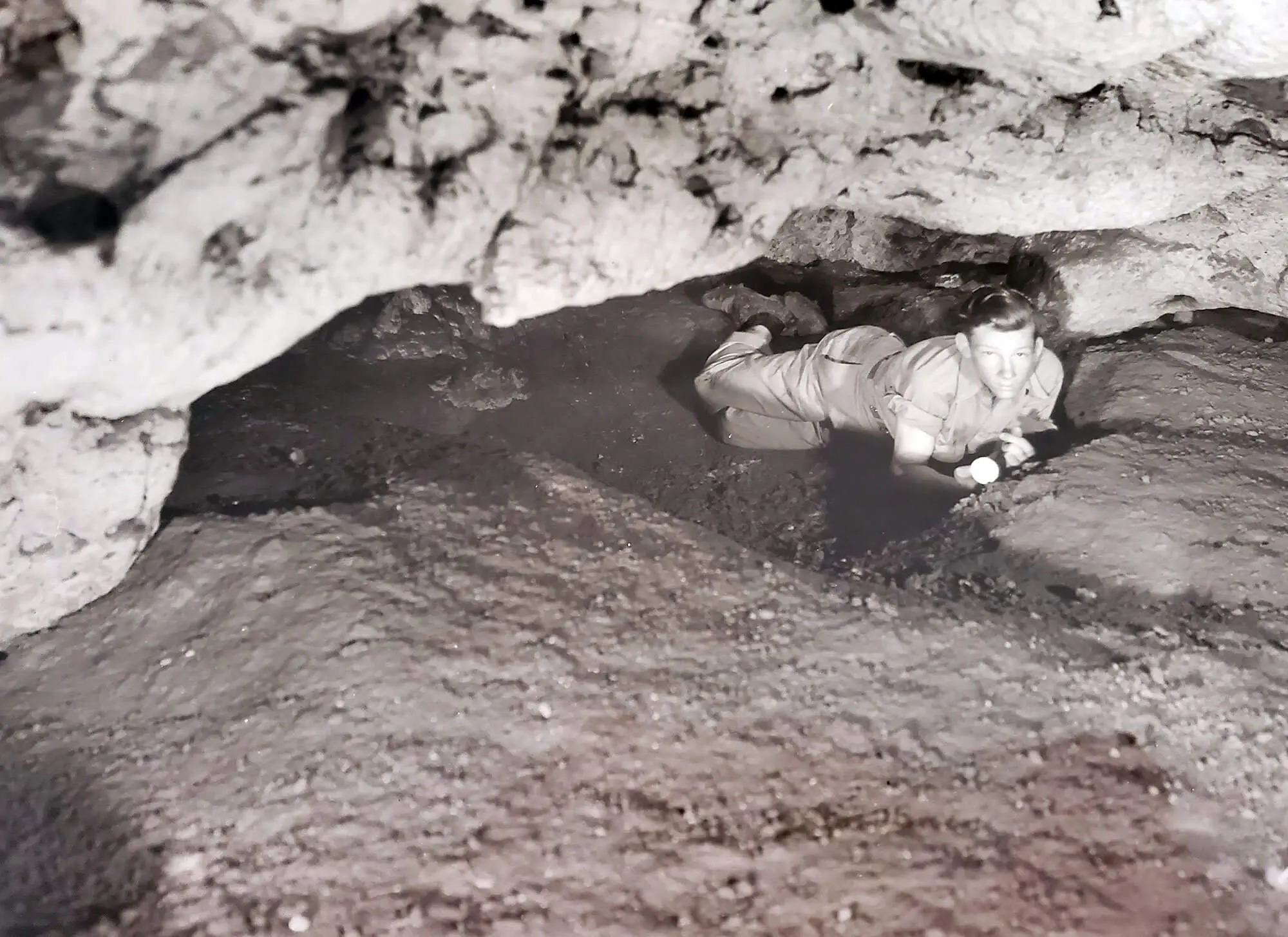 Black and white photo of a young man laying in Meramec Caverns